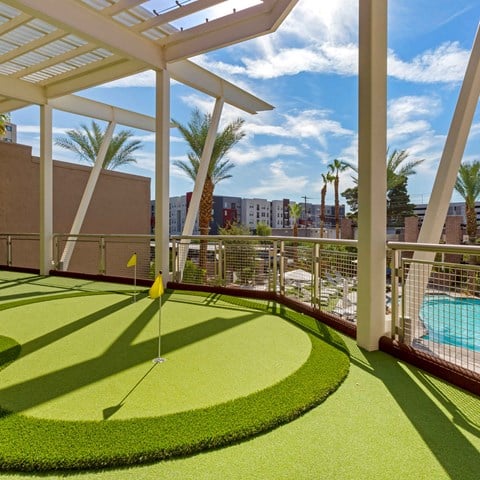 a putting green on a balcony with a pool